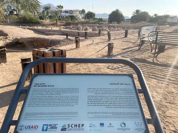 Sign and landscape with ruins, Ayla/Aqaba, Jordan, by Kareem Rosshandler,